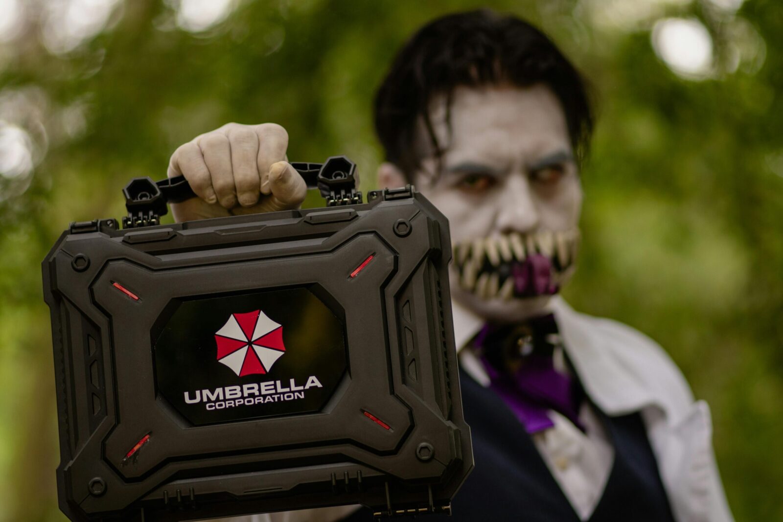 A cosplayer holding an Umbrella Corporation case, inspired by Resident Evil, ready for Halloween.