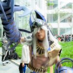Young adult in cosplay costume at outdoor event with futuristic armor.