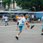 Dynamic scene of foot volleyball with young adults playing energetically outdoors.